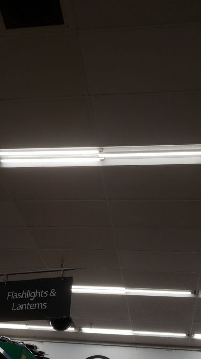 My local Walmart is starting to use indoor LEDs.
Picture taken yesterday.

Well, in this case they are using Philips instant fit retrofit LED tubes. Which is smart, because replacing the whole fixture cost much more than putting these LED retrofit tubes. Half of these fixtures still have regular GE Ecolux fluorescent tubes.
Keywords: Lit_Lighting