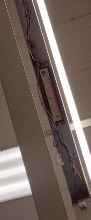 Damaged fluorescent fixture 
Sorry for the bad camera angle. It looks like it has a Universal Triad electronic ballast.
Keywords: Lit_Lighting