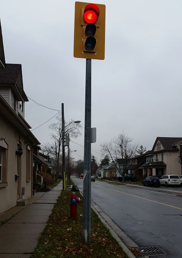 Eagle Durasig on short Niagara style pole.
This is one signal setup like this I know of here, in fact even the whole GTA! Niagara region uses them quite a bit still (close to USA/Canada Border, Buffalo, for some of you who dont know where Niagara is) Its held up from the bottom and looks like it was just screwed into the pole.
Keywords: Traffic_Lights