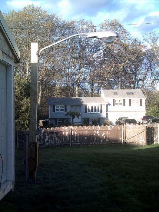 My 1987 70W HPS American Electric 113 On My New Pole!
With a DTL photocell and a Sylvania Ecologic lamp. The 6x6 post itself is 8ft long and the base sticks out about 2ft so the light is like 10ft off the ground. 
Keywords: American_Streetlights