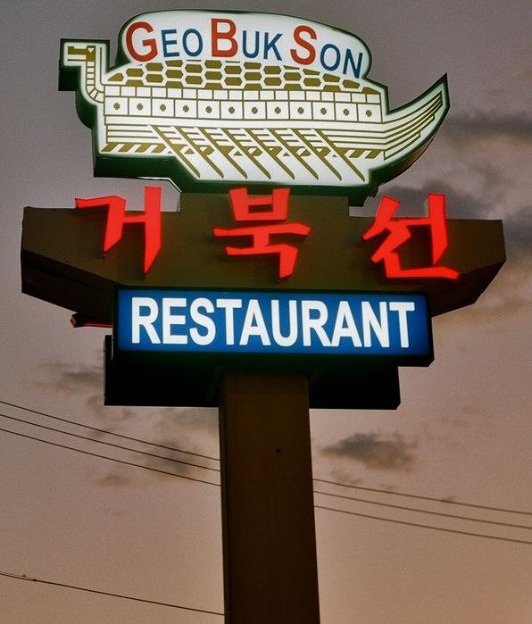 Neon/Fluorescent sign
The Chinese characters in the middle are neon and "Restaurant" is obviously fluorescent, but I'm not sure about the top. If I had to guess, I'd say fluorescent.
