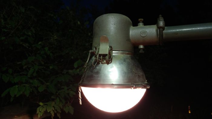 LM Spherolite Jr. 
Found this at Restore. I was a bit surprised to see this amongst the other residential outdoor lights.  It's shown here mounted temporarily on my deck with the straight GE arm it came with. 

It also came with a 189w 2500 lumen streetlighting bulb which is the bulb in the pic. My first real streetlighting incandescent bulb too. 

It's similar in overall size to my Powerlite mini gumball except this is slightly shorter due to the shallower glass. Interestingly this uses a standard NEMA style latch like a full sized gumball. The optical assembly and head is smaller than a standard gumball though. 
Keywords: American_Streetlights