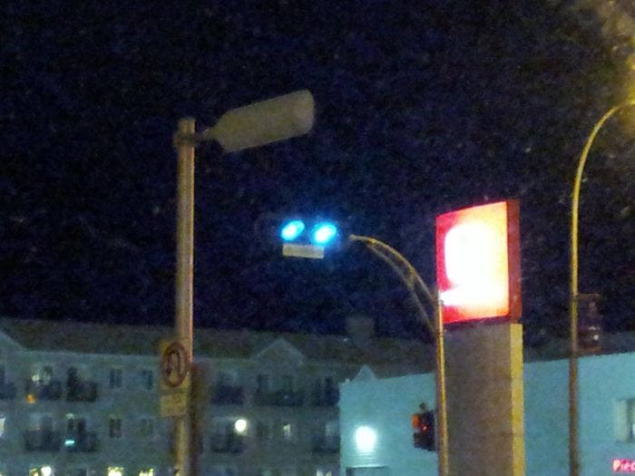 A double-green??
Here's something extremely weird!

Doubling the red light is a common practice in Qubec to make it more visible and emphasize the fact you have to stop. But never have I seen a double-green light! As a side note this is one of the only newer LED traffic lights to use the special shapes designed for colourblind people. There are already two red lights as well. With the yellow and one green a 4-light unit would be enough using that configuration, so I can't tell why they took a 5-light unit, or why they didn't use the remaining light to make a protected left turn sequence.

By the way as of this week, one of those green lights (the left one I think) is out.
Keywords: Traffic_Lights