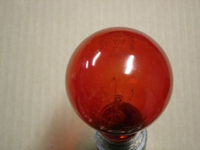 Sylvania 25W Incandescent
Here's a transparent red Sylvania lamp,it has "replacement group" on the etch.
Voltage: 125V
Filament: CC-9
Lamp shape: A19

Keywords: Lamps