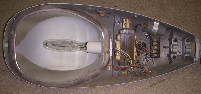 ITT Model 25 FCO inside.
Man that ballast is HUGE! For just 250 watts High Pressure Sodium 120 volt??

This was avter I did a hefty vaccum of the inside, it was COVERED in dirt! At least most of it is cleaner now, BUT, dirt still wants to fall out of the gasket.

There seems to be two ignitors in here just like the other one. If both of them work I can use the extra ignitor for my 125 400w HPS ballast that lacked a working ignitor!

The old ignitor mounted on the fixture is branded "ITT" While the ignitor not mounted anywhere (just hanging loose) but connected in the circuit is branded "AEL" so I guess that ignitor was replaced during service.

The lamp was bought at the Habitat for Humanity ReStore, (a different one, not the one I got that florescent fixture) for only TWO BUCKS! Woah. Two dollars for a 250w HPS lamp? That looks brand new? o.o
Keywords: American_Streetlights