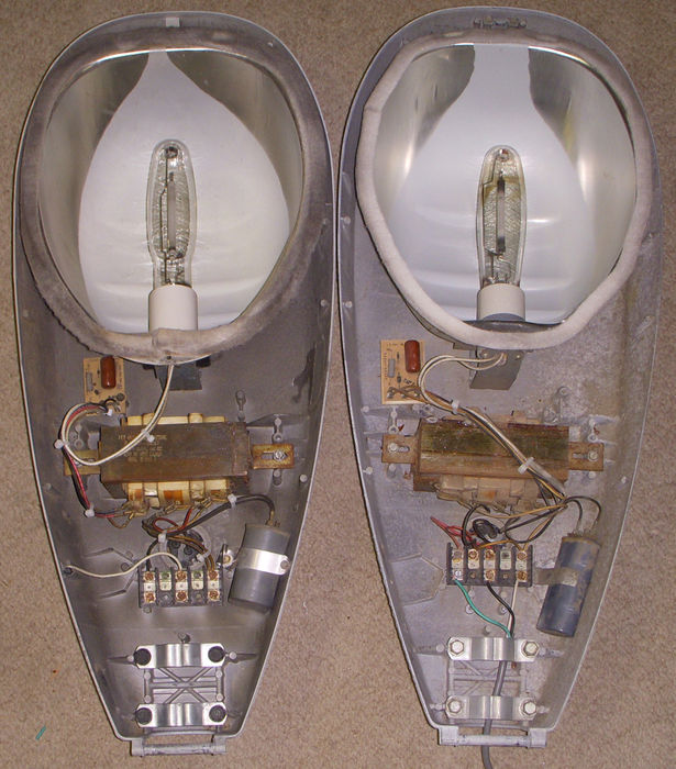 The insides of the Model 25 FCO's.
Here are the insides of them, you can see differences here too. Like how the ballasts are wired.

Also the capacitor ont he OLDER one is a bit smaller while the newer one is bigger.

The ballasts are the same size though.

The reflectors are a bit different, the older Model 25 has a better condition reflector, and the paint seems new in there!

The sockets are mounted differently. In the newer Model 25 the socket used to be connected to the reflector by a metal plate, but I took that out. And also the newer one has a screw on the socket and the screw screws in the reflector (Under the gasket)  to the socket metal.

The older one is just the socket is held in by a screw, and the reflector just slides in and then screws. There was no metal plate at all. Just a rubber grey gasket to keep bugs out. (Ugh them bugs.)

Not really any other notable differences.
Keywords: American_Streetlights
