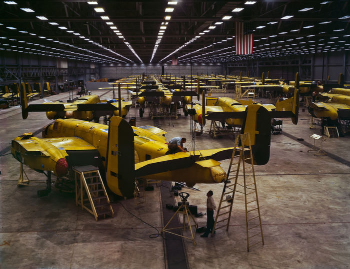 B-25 Bomber Plant - 1942 
Found this nice and clear colour shot of a WWII era bomber plant. Look what looks to be a ton of three lamp T17 preheat units in use here. As you can see some of the lamps are dead and there's also a couple of lamps with stuck starters. 

Source:
[url=http://en.wikipedia.org/wiki/File:FSAC.1a35291_Assembling_B-25_bombers_at_North_American_Aviation,_Kansas_City.jpg]Wikipedia[/url] 

"Assembling B-25 bombers at North American Aviation, Kansas City, Kansas." 

Some more info: "The B-25 Mitchell. This photo is at the North American Aviation plant in Kansas. Of the 10,000 or so produced, 6,500 were made by Ford at the Willow Run plant, the largest single building under one roof in its day. Employees used bicycles to get around because the facility was so large. After the B-17 it was the workhorse of WW II. The biggest advantage of the B-25 was it could take off in 700 feet of runway. Col James Doolittle flew them off the deck of an aircraft carrier to bomb Japan!
"
Keywords: Miscellaneous
