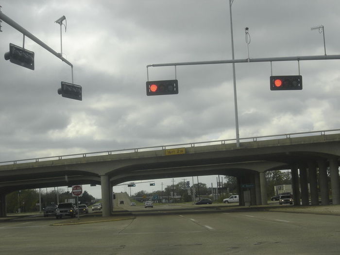 The Traffic Signals are Lowered here to See Under the Overpass...
at this Particular Intersection...the Traffic Lights have extensions that Lower then so they are able to Be Seen Under the Overpasses.

Overpass is Interstate 45.
Keywords: Traffic_Lights