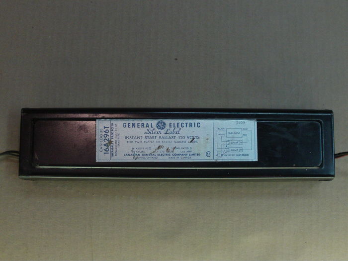 General Electric 16A296T Silver Label slimline ballast.
Here's a little surprise found among steel scrap at school! I was taking EMT scraps to the steel dumpster and I found a weirdo slimline fixture laying on top, showing this huge ballast! I obviously couldn't take the whole thing so I asked my teacher for the ballast, saying that "it probably still works". He let me have it, as you can see.

1963 vintage! My oldest slimline ballast and the oldest one I've seen too! And amazingly, it still works! Despite being sound rated D, it is far from being loud...
Keywords: Gear