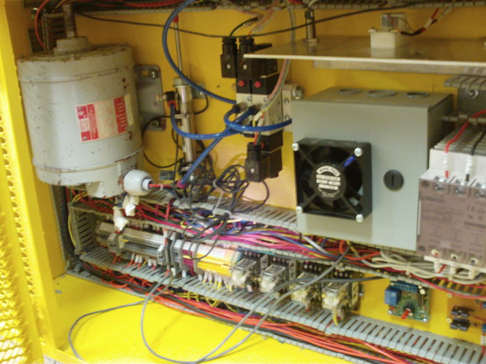 Closer view of "M" machine.
Here you can see the 3-phase motor, some terminals and relays in the lower part of the panel, a gray box containing three power resistors, a solid state relay controlling the power resistors, and a pneumatic cylinder driven by three electrodistributors.
Keywords: Miscellaneous