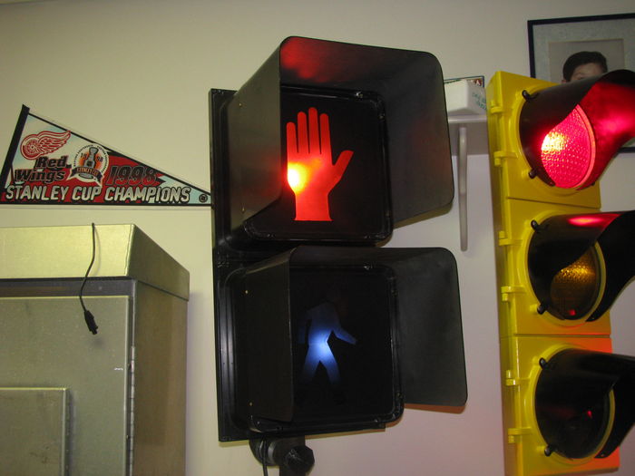 12 inch Eagle DuraSig
The pedestrian signal version of the DuraSig model. This one was made in 1990. It remains at a constant "hand" until a call for walk is placed by pushing the button. 
Keywords: Traffic_Lights