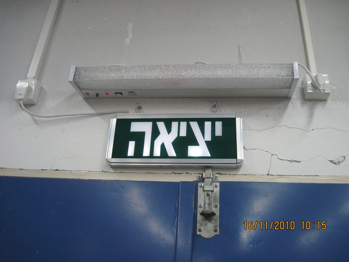 A LED Exit sign of Electrozen in the storage of Carmel hospital
It is available with either green or white (Here) LEDs, but the sign always colored green.
You can see how dim it is (This picture, show it in the day of its installation), relative to a hypothetical green version of the Canadian common incandescent EXIT/SORTIE sign.
Despite this, it is still visible in the darkness (It have an emergency battery of NiCd for operating the sign during a power interruption for 3 hours).
Keywords: Misc_Fixtures