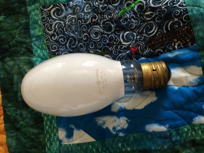 GE /W! 
This 175w High-Output White mercury vapor lamp was given to me by fellow member Icefoglights in a trade.  It's not a Bonusline so I think it's a little newer, but I'm thinking late '60s or early '70s.  

It does work, and is quite bright and lightly used.  I certainly like its light quality much more than a /DX, not so pink. 

The /W (High-Output White) was, as I understand it, an early attempt at increasing light output while diffusing the light.  It did now, however, particularly improve color, hence the light quality isn't much better than that of a clear or /D (Diffused) lamp.  I would describe it as rendering reds slightly better, but only slightly.  It definitely has a greenish tone to it.  I'd seen /W lit, but only in pictures, never in person.  Definitely not pink like a /DX, and alsi it lacks that "fluorescent" effect /DX has; white paper doesn't fluoresce under the light of this lamp like happens with /DX.  I personally also find the light much less harsh and jarring than that of /DX; I could happily work under /W but not /DX indoors as an only light source.  Later lamps (aka /DX) improved light output in addition to CRI, but I personally prefer the light of /W over /DX hands down.  
Keywords: Lamps