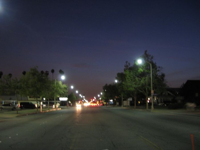 Pomona Induction Streetlights Lit
Looking west from the middle of Holt Blvd in Pomona with induction converted streetlights lit. 

If you didn't know these were induction, would you have though Mercury Vapor made a comeback ?
Keywords: Lit_Lighting