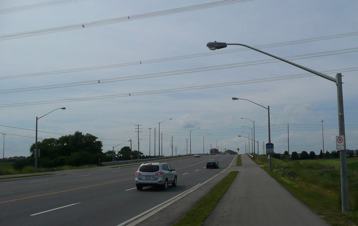 Streetlight Design Under Powerlines
Here is one of the best light distribution designs for having to mount lights lower under high voltage lines over the road (pole spacing, arm length, 3 pole heights depending on interference distance from lines above, symmetrical on each side of the road). The contractor didn't implement it with consistent parts, note how one side of the road has some different luminaires and aluminum arms with different bends.
Keywords: American_Streetlights