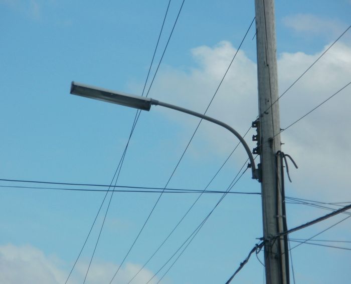 Fluorescent Streetlight
Here's a picture of a fluorescent streetlight that's part of a string of around ten of these. I was surprised to see these still in service here since most older streetlights here were wiped out by HPS conversions during the 1980's-1990's. This is a retaken picture of my previous pic. I might have a chance to get a night pic around a month or so from now of these lights. 

I would also appreciate any info about the manufacturer/model.
Keywords: American_Streetlights