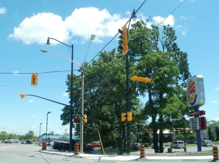 Temporary and Permanent Traffic Signals and Streetlights. 
Here's a shot of some temporary traffic signals and streetlights along with some new King Luminaire K833 reproduction teardrop fixtures on a city street in Brampton. You could also see the unused new signal mounted so that they are facing away from traffic since they 're not in service yet.  
Keywords: American_Streetlights