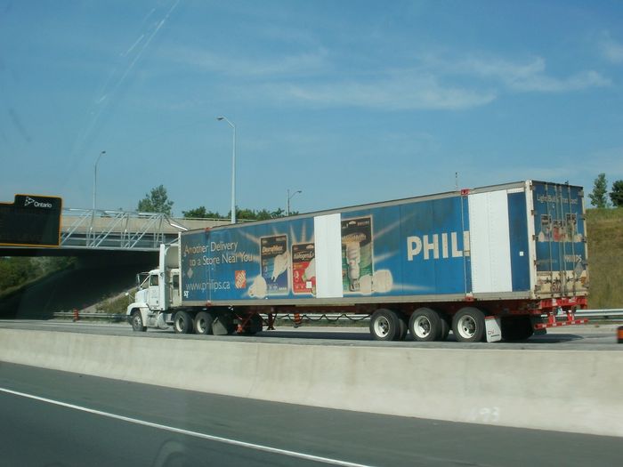 Philips Lighting Truck 
Here's a pic of a truck on Highway 401 with some ads on it for Philips light bulbs and CFLs carrying what I presume are Philips light bulbs. Note the Home Depot logo near the front of the trailer telling consumers where to buy Philips products and the phrase "Light Bulbs That Last!" on the back of the trailer. Now of course the F34/40 Altos that they make seem to prove otherwise. :D   
Keywords: Miscellaneous