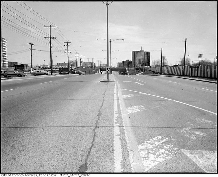 Eglinton and Bellamy
Eglinton and Bellamy looking east, probably in late 60s-early 70s or so. Note the median mounted mercury clamshells on double guy arms, the CGE signals on double guy arms in the background, and the illuminated median keep right sign. 

[url=https://maps.google.ca/maps?q=Eglinton+Station,+Toronto,+ON&hl=en&ll=43.740034,-79.232712&spn=0.016216,0.042272&sll=49.303974,-84.738437&sspn=14.883657,43.286133&oq=eglinton+s&hnear=Eglinton+Station&t=m&z=15&layer=c&cbll=43.740018,-79.232826&panoid=RWkLdoCcZZrofmW7GMGmnA&cbp=12,77.57,,0,-5.85]Streetview,[/url] there is still one double guy signal arm left but it looks like the utilty pole it was one and the CGE signal it once held have long since been replaced.  
Keywords: American_Streetlights