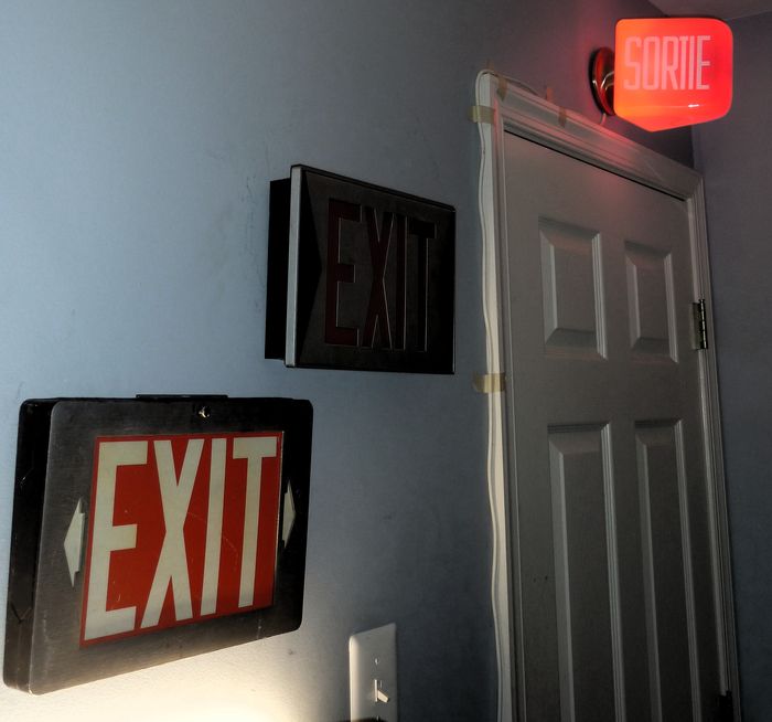 Exit signs installed! 
I have the Sortie one securely screwed to the studs using a very shallow receptacle box, you can see the fixture isn't totally flushed. The masking tape idea is  temporary....

The other exit signs will get powered sometime soon. 
Keywords: Misc_Fixtures